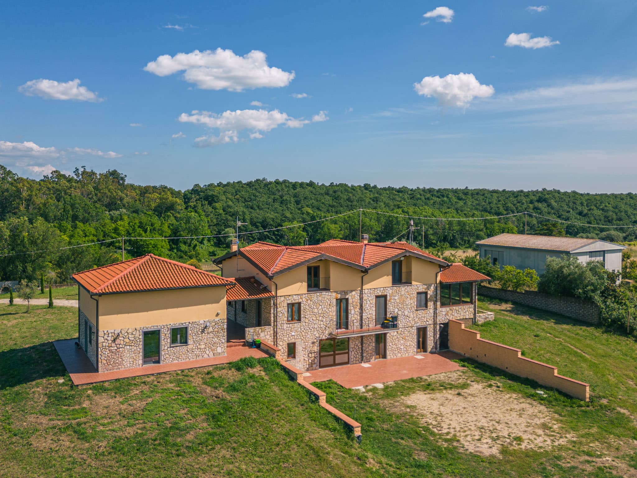 Casa di campagna con tetto rosso e giardino verde.